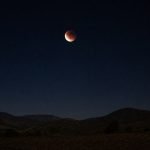 Eclipse lunar parcial sobre un paisaje nocturno del valle de Casablanca