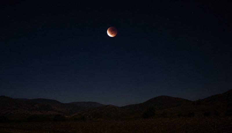 Eclipse lunar parcial sobre un paisaje nocturno del valle de Casablanca