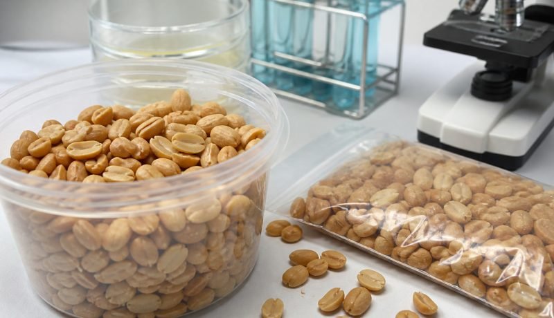 Maní tostado en envases sin marca junto a elementos de análisis de laboratorio