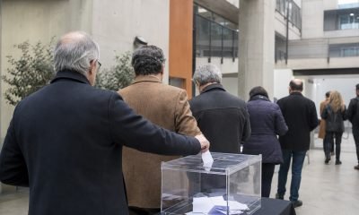 Jornada electoral académica genérica con docentes y una urna transparente