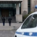 Edificio judicial genérico con funcionarios caminando hacia su acceso