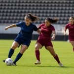 Futbolistas mujeres disputan el balón durante un partido en un estadio genérico