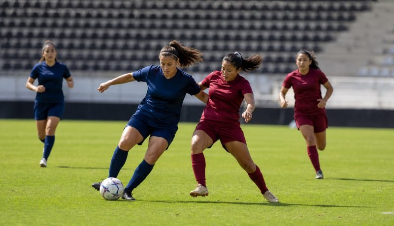 Futbolistas mujeres disputan el balón durante un partido en un estadio genérico
