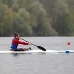 Deportista adulta compite en paracanotaje sobre una pista de aguas tranquilas