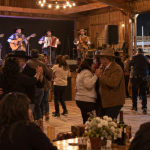 Parejas bailan mientras un conjunto ranchero toca en un recinto rural de Casablanca