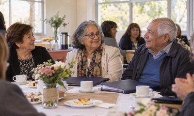 Tres personas comparten un desayuno de reconocimiento por su trayectoria educativa