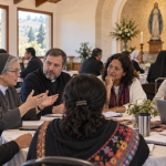 Delegaciones religiosas y laicas conversan alrededor de una mesa en un santuario