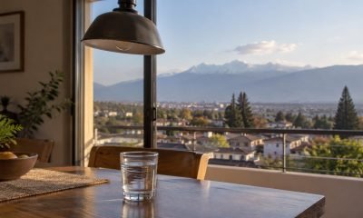 Vaso de agua con ondas suaves frente a una vista urbana y cordillerana de la zona central