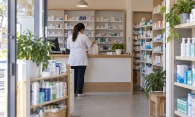 Profesional prepara un pedido en el mostrador de una farmacia de barrio