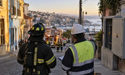 Bombero y técnico eléctrico coordinan una emergencia en una calle de Valparaíso en una imagen editorial referencial