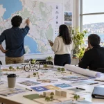 Equipo técnico trabaja con mapas y modelos de movilidad urbana en una imagen editorial referencial