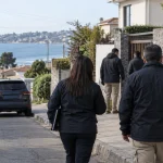 Equipo investigador se aproxima a una vivienda durante un procedimiento en una imagen editorial referencial