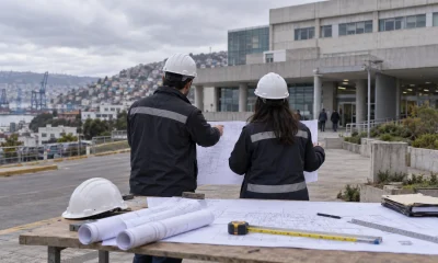 Profesionales revisan planos de infraestructura frente a un hospital en una imagen editorial referencial