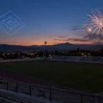 Representación editorial de las alternativas de drones y fuegos artificiales sobre un estadio vacío al anochecer