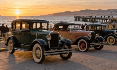 Automóviles de fines de la década de 1920 en una exhibición patrimonial junto al borde costero, imagen editorial referencial