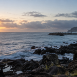 Vista costera referencial de Rapa Nui con una embarcación distante