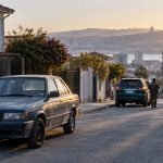 Automóvil antiguo estacionado en una calle con personal de seguridad a distancia