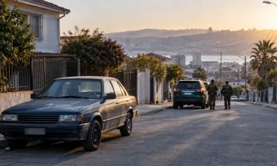 Automóvil antiguo estacionado en una calle con personal de seguridad a distancia