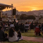 Festival de música comunitario en un estadio municipal al atardecer