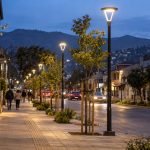 Luminarias peatonales encendidas al atardecer en una avenida urbana de la zona central de Chile