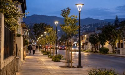 Luminarias peatonales encendidas al atardecer en una avenida urbana de la zona central de Chile