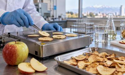 Investigadora manipula láminas de manzana durante una prueba de deshidratación en laboratorio
