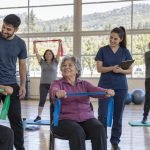 Personas mayores realizan actividad física guiada en un recinto comunitario