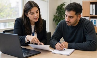 Orientadora laboral ayuda a una persona a revisar su currículum en una oficina