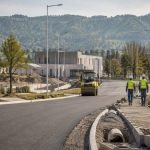 Imagen editorial de una avenida en obras con maquinaria y trabajadores