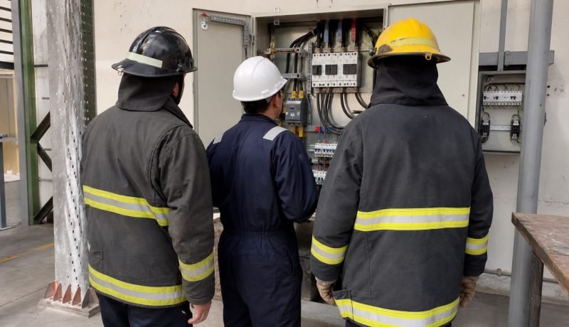 Bomberos revisan un tablero eléctrico durante una capacitación de seguridad