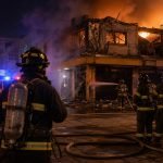 Ilustración de bomberos combatiendo un incendio estructural durante la noche