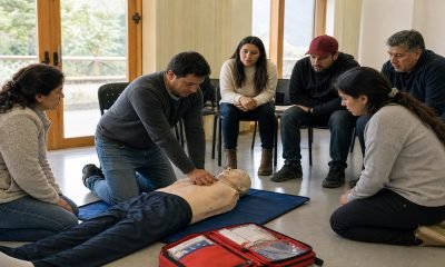 Grupo de trabajadores practica reanimación cardiopulmonar con un maniquí de entrenamiento