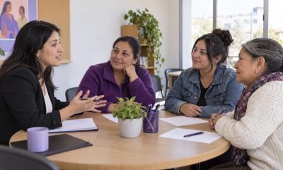 Representación editorial de una orientadora conversando con tres mujeres en una mesa comunitaria
