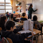 Estudiantes de educación básica trabajan lectura y matemáticas en una sala de clases