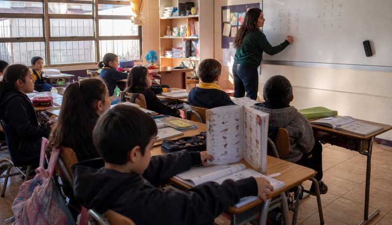 Estudiantes de educación básica trabajan lectura y matemáticas en una sala de clases