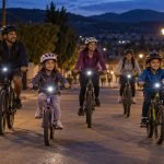 Familias con casco y luces pedalean de noche por una calle de Casablanca