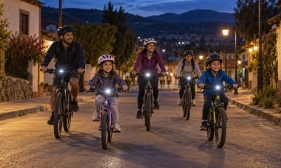 Familias con casco y luces pedalean de noche por una calle de Casablanca