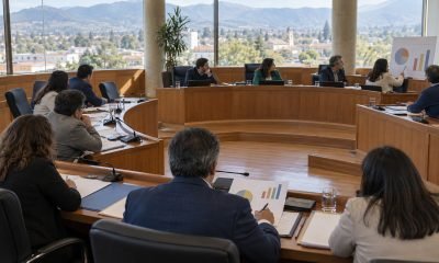 Ilustración editorial de una sesión de concejo municipal sobre presupuesto y educación