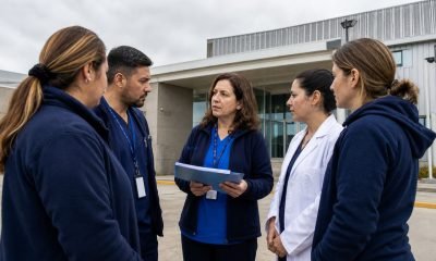 Funcionarios de salud municipal conversan frente a un centro de atención primaria en una imagen referencial