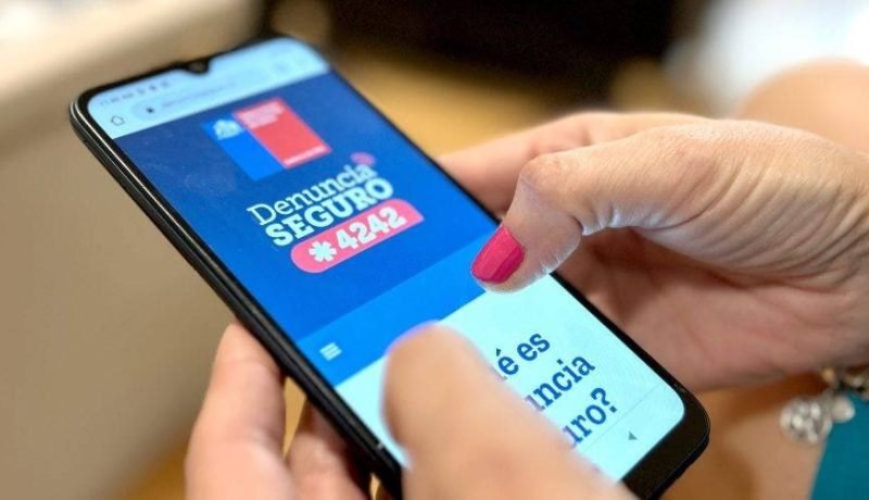 Persona consulta en un teléfono el sitio del programa Denuncia Seguro y su número *4242