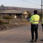 Dos técnicos revisan un diagnóstico frente a una vivienda rural de la Región de Valparaíso