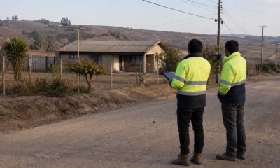 Dos técnicos revisan un diagnóstico frente a una vivienda rural de la Región de Valparaíso