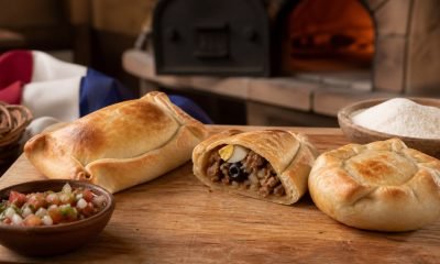 Empanadas chilenas de pino y pequén recién horneadas en una mesa de cocina