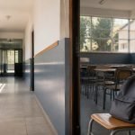 Pasillo y sala de clases con una mochila escolar