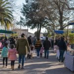 Familias recorren una feria comunitaria con puestos de emprendedores