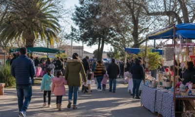 Familias recorren una feria comunitaria con puestos de emprendedores