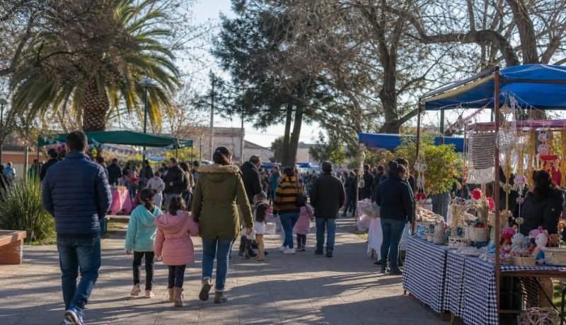 Familias recorren una feria comunitaria con puestos de emprendedores