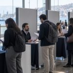 Personas conversan con equipos de reclutamiento en una feria laboral