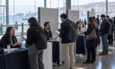 Personas conversan con equipos de reclutamiento en una feria laboral