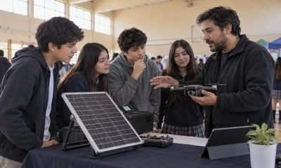 Estudiantes observan un panel solar y un dron durante una feria tecnológica